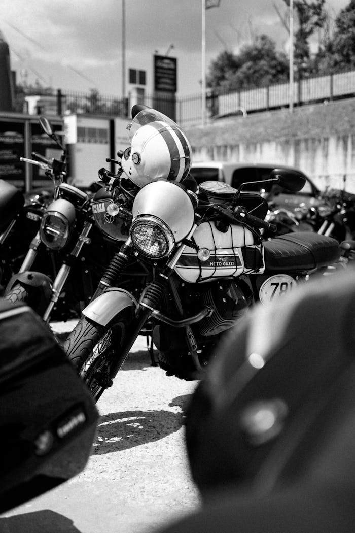 Black and white image of classic motorcycles parked in a row, capturing vintage charm.